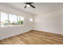 Bright living room with modern ceiling fan, wood-look floors, and natural light from large window at 162 N Hunt W Dr, Mesa, AZ 85203