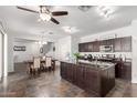 Open-concept kitchen with dark cabinetry, stainless appliances, and granite island flows into dining area at 21014 W Ridge Rd, Buckeye, AZ 85396