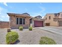 Single-story home with stone accents, desert landscaping, and a two-car garage on a sunny day at 23886 W Harrison Dr, Buckeye, AZ 85326