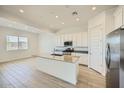 Bright kitchen features an island with sink, stainless steel appliances and white cabinets at 25162 N 177Th Dr, Surprise, AZ 85387