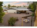 Large backyard with patio cover, fire pit, and mature trees create an inviting outdoor space at 2726 W Meseto Cir, Mesa, AZ 85202