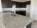 Bright kitchen featuring dark cabinets and granite countertops at 32002 N Pony Express Rd, San Tan Valley, AZ 85143