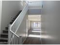 Bright foyer with carpeted stairs, white railing, wood-look floors and open sight lines to a living space at 3363 S 180Th Ln, Goodyear, AZ 85338