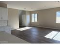 Bright living room with wood-look floors and large windows, open to the kitchen and stairs to the upper level at 3363 S 180Th Ln, Goodyear, AZ 85338