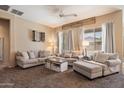 Comfortable living room with plush sofas, a ceiling fan, and lots of natural light from large windows at 35414 N 32Nd Dr, Phoenix, AZ 85086