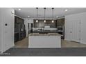 Modern kitchen with granite countertops, an island with a sink, and stainless steel appliances, perfect for cooking enthusiasts at 36602 W San Alvarez Ave, Maricopa, AZ 85138