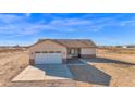 Single-Gathering home featuring a two-car garage, desert landscaping, and neutral stucco at 37504 W Elm Ave, Tonopah, AZ 85354