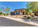 Charming two-story home boasting a blue garage door, desert landscaping, and tile roof at 3804 E Daley Ln, Phoenix, AZ 85050