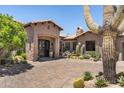 Beautiful desert home featuring a circular brick driveway, desert landscaping and an arched entry at 41916 N 101St N Pl, Scottsdale, AZ 85262