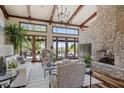 Bright living room featuring high, beamed ceilings, wood floors, a stone fireplace, and large windows at 41916 N 101St N Pl, Scottsdale, AZ 85262