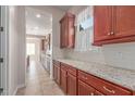 A view of the kitchen with granite countertops, wood cabinets, white subway tile backsplash, and stainless steel appliances at 4724 S Anitole Way, Mesa, AZ 85212