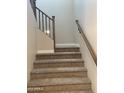 Carpeted staircase with wooden railing offers access to the upper levels of the home at 4930 W Brown St, Glendale, AZ 85302