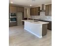 Modern kitchen with a large island, stainless steel appliances, and stone backsplash at 5004 W Brown St, Glendale, AZ 85302