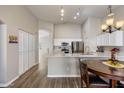 Bright, open kitchen featuring white cabinetry, stainless steel appliances, and a breakfast bar at 635 S Lanus Dr, Gilbert, AZ 85296