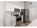 Modern kitchen appliances including stainless steel refrigerator, microwave, and oven with white cabinets at 635 S Lanus Dr, Gilbert, AZ 85296