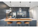 Contemporary kitchen featuring a breakfast bar with stools, pendant lighting, and modern appliances at 7180 E Kierland Blvd # 1116, Scottsdale, AZ 85254