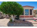 Charming exterior with well-manicured landscaping, featuring a golf cart and cozy porch area at 8700 E University Dr # 1205, Mesa, AZ 85207