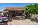 Charming home with covered porch, mature tree, and golf cart for convenient living at 8700 E University Dr # 1205, Mesa, AZ 85207
