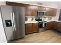 Kitchen with stainless steel refrigerator, microwave, and oven, paired with brown cabinets and white countertops at 903 W Jacinto Cir, Mesa, AZ 85210