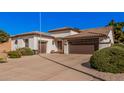 Inviting single-level home with a well-manicured yard, desert landscaping, and two-car garage at 10529 E Posada Ave, Mesa, AZ 85212