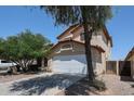 Two story home featuring a driveway, two car garage, desert landscaping, and a red tile roof at 12408 W Orange Dr, Litchfield Park, AZ 85340