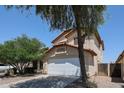 Two story home featuring a driveway, two car garage, desert landscaping, and a red tile roof at 12408 W Orange Dr, Litchfield Park, AZ 85340