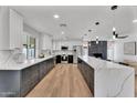 Spacious kitchen featuring stylish two-tone cabinetry, sleek countertops, stainless steel appliances, and hardwood flooring at 13224 N 31St Pl, Phoenix, AZ 85032