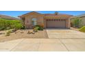 Front exterior showcasing desert landscaping, a spacious driveway, and a two-car garage at 14333 W Alvarado Dr, Goodyear, AZ 85395