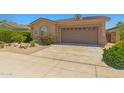 A front exterior with a concrete driveway, desert landscaping, and a home with a two-car garage at 14333 W Alvarado Dr, Goodyear, AZ 85395