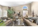Cozy living room featuring plush sofas, stylish decor, and a bright arched window at 1449 W Sherri Dr, Gilbert, AZ 85233