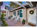 Inviting front porch featuring rocking chairs and a small table, perfect for relaxing outdoors at 16437 N 61St Ave, Glendale, AZ 85306