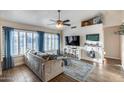 Cozy living room with natural light, wood floors, ceiling fan, and comfortable seating at 16437 N 61St Ave, Glendale, AZ 85306
