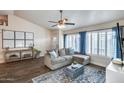 Inviting living room with wood floors, comfortable sofa, and large windows with plantation shutters at 16437 N 61St Ave, Glendale, AZ 85306