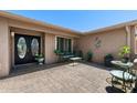 Inviting front porch with seating, potted plants, decorative metal art, and a double-door entrance at 1753 Leisure World --, Mesa, AZ 85206