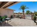 Open-air patio features a bistro set and a view of the desert landscaping and gated front yard at 1753 Leisure World --, Mesa, AZ 85206