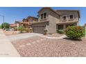 View of a two-story home with desert landscaping, and a two-car garage at 17560 W Young St, Surprise, AZ 85388