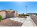 Single-story home with a large driveway and neutral color scheme in a residential neighborhood at 19595 W San Miguel Ave, Litchfield Park, AZ 85340