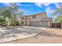 Spacious three car garage with mature trees in the desert landscaping on this two-story home at 308 E Sheffield Ct, Gilbert, AZ 85296