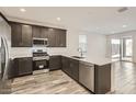 Modern kitchen featuring stainless steel appliances, dark cabinets, quartz countertops, and an open layout at 3129 S 155Th Ln, Goodyear, AZ 85338