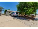 View of the front of the home with driveway, silver car, grassy area, and fenced yard at 3226 W Grovers Ave, Phoenix, AZ 85053