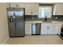 Close up of a kitchen featuring stainless steel appliances, white cabinets, and a gray backsplash at 4425 W Sierra St, Glendale, AZ 85304