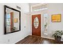 Bright foyer with wood floors, decorative front door, large mirror, and a view of the outdoor space at 4563 E Libby St, Phoenix, AZ 85032