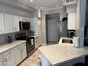 Bright kitchen with stainless steel appliances, white cabinetry, quartz counters, and wood look flooring at 5335 E Shea Blvd Blvd # 2095, Scottsdale, AZ 85254