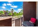Private balcony featuring a small table and chair with views of the community and sunny skies at 6745 N 93Rd Ave # 1129, Glendale, AZ 85305