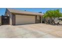 View of the home's exterior and driveway, showing the two-car garage and 'Beware of Dog' sign at 6802 S 47Th St, Phoenix, AZ 85042