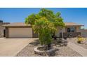 Charming single-story home featuring a xeriscaped front yard, mature tree, and a neutral color palette at 6802 S 47Th St, Phoenix, AZ 85042