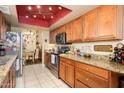 Warm kitchen featuring granite countertops, wood cabinets, and stainless steel appliances at 7635 S Taylor Dr, Tempe, AZ 85284