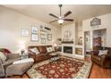 Comfortable living room featuring a fireplace, ceiling fan, and neutral color scheme at 7635 S Taylor Dr, Tempe, AZ 85284