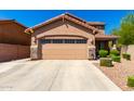 A well-maintained two-car garage with a concrete driveway and manicured landscaping at 778 W Lowell Dr, San Tan Valley, AZ 85140