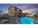 Backyard view of a refreshing pool with rock waterfall feature and covered patio at 778 W Lowell Dr, San Tan Valley, AZ 85140